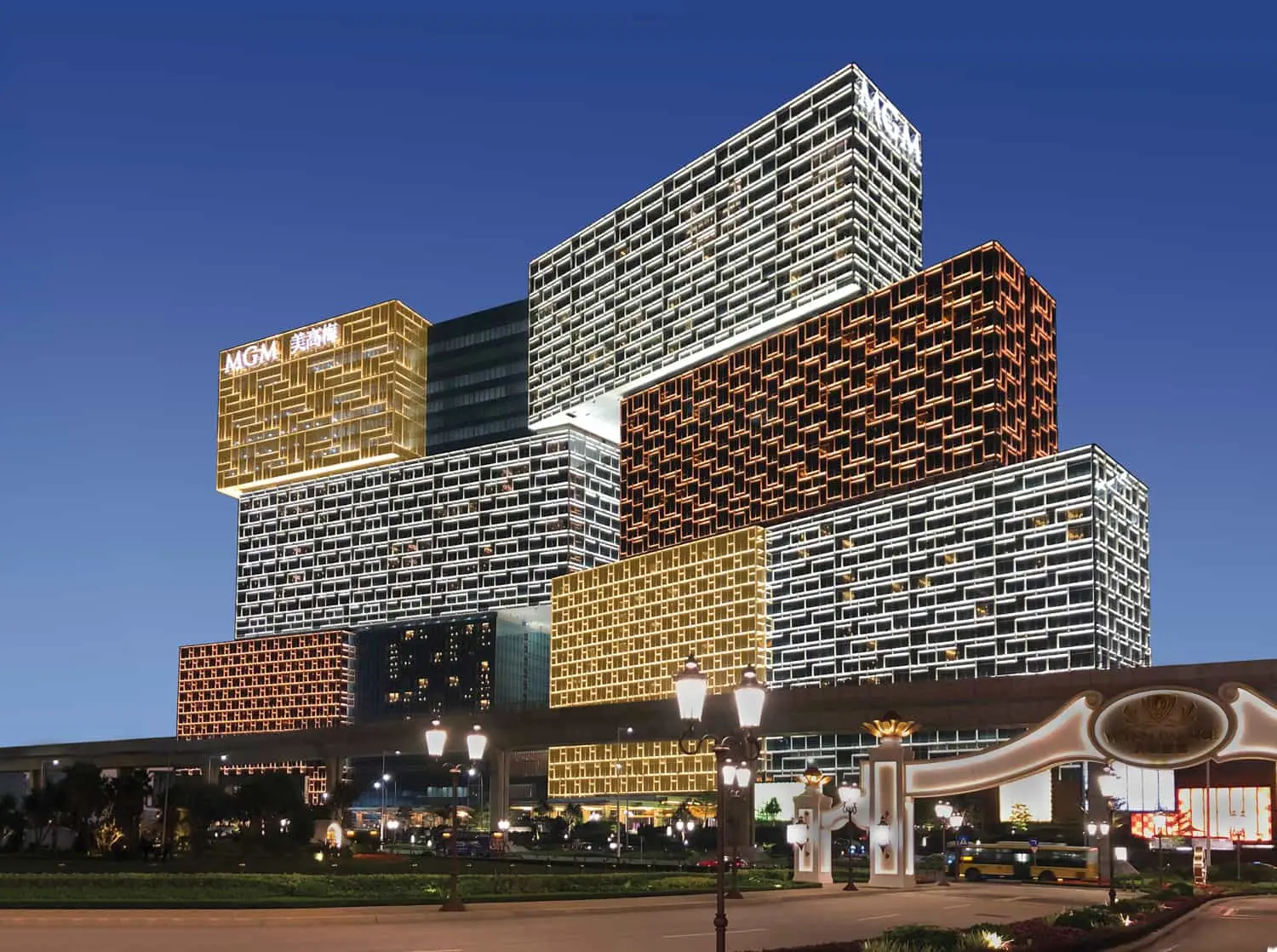 MGM Cotai exterior in Macau at night, showing the illuminated stacked hotel towers and main resort entrance.